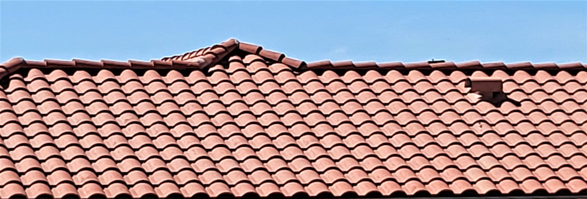 Red Tile Roof! Shaped Roof Tiles on the Roof of a Home Under a Beautiful Sky of Blue!